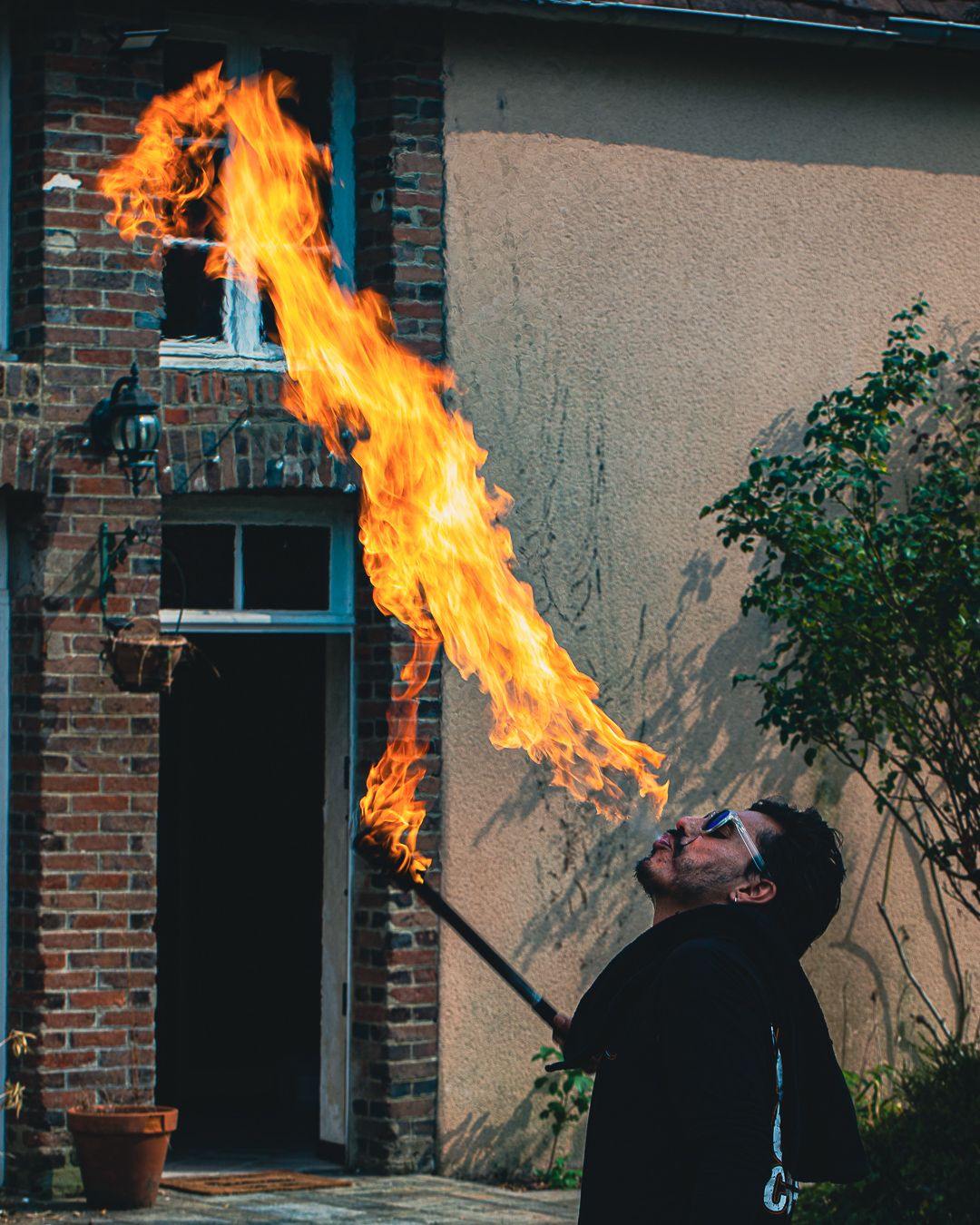 Danny Perez, Cracheur de Feu devant la façade de Fairy House — circodelfuego.com